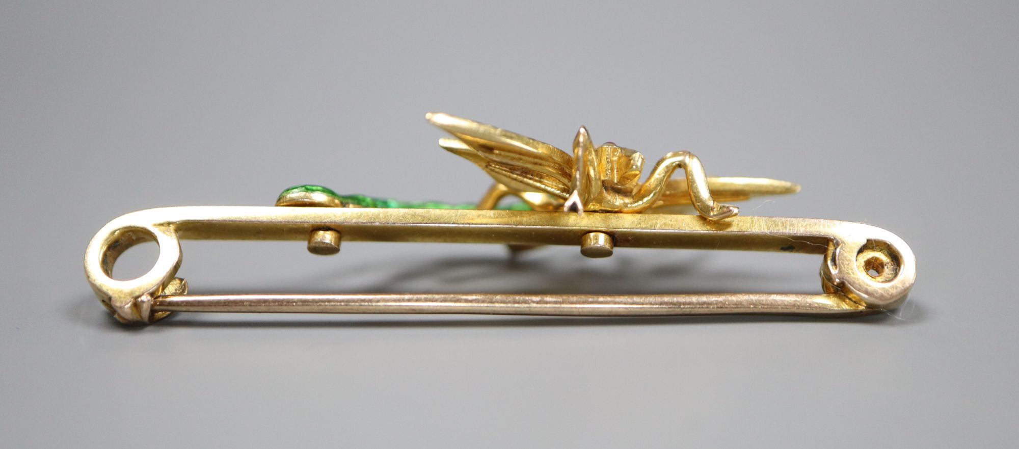 An Edwardian yellow metal, garnet?, seed pearl and green enamel set dragonfly bar brooch, 51mm, gross 6.7 grams.